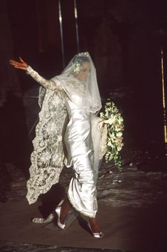 the bride is walking down the street in her wedding dress