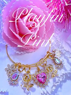 a close up of a pink flower and a gold bracelet