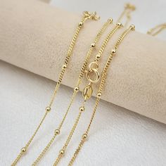 💓 Beautiful solid 14k yellow gold dainty curb beads necklaces. Perfect for everyday and every occasion. Unique, versatile and everlasting. 14k gold will not tarnish or rust. You will never want to take it off 😍 💓 Materials: 14k solid yellow gold Length and weight: 14" - 1.85 grams 16" - 2  grams 18" - 2.3 grams 20" - 2.5 grams 22" - 2.75 grams (Approximately) Thickness: 1mm beads: 2mm 14kt stamped Spring ring lock 💓Briza Collections is a small family-owned business that works hard on providi 14k Gold Satellite Chain Necklace For Anniversary, Yellow Gold Beaded Chain Necklace, Yellow Gold Satellite Chain Necklace With Round Beads, Tarnish Resistant Yellow Gold Chain Necklace For Jewelry Making, 14k Gold Beaded Chain Necklace With Round Beads, 14k Gold Beaded Chain Necklace, 14k Gold Dainty Necklace With Round Beads, Yellow Gold Jewelry With Satellite Chain For Anniversary, Dainty 14k Gold Round Bead Necklace