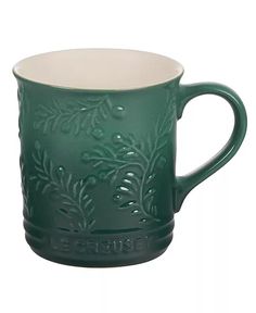 a green coffee cup with leaves on it