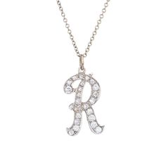 Stylish vintage letter "R" diamond necklace crafted in 14 karat white gold (circa 1960s).    Diamonds total an estimated 0.65 carats (estimated at H-I color and SI1-2 clarity).    The retro letter "R" is set with sparkling diamonds. The 18" necklace is great worn alone or layered with your fine jewelry from any era.    The necklace is in very good original condition and was recently professionally cleaned and polished.    Particulars:    Weight: 4.5 grams    Stones: Diamonds total an estimated 0.65 carats (estimated at H-I color and SI1-2 clarity).    Size & Measurements: The necklace measures 18 inches in length. The letter R measures 1 x 1/2 inch.    Metal & Hallmark: 14k white gold. The necklace is hallmarked "14k" Masonic Jewelry, Art Deco Pendant Necklace, Russian Jewelry, White Gold Pendant Necklace, Diamond Initial Necklace, Antique Jewelry Necklace, Necklace Craft, Art Nouveau Jewelry, Letter R