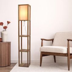 a living room with a chair and a tall wooden shelf next to a white wall