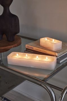 two candles sitting on top of a glass table