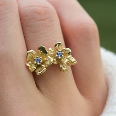 Title:  Cherry Blossom Ring Material: Solid Yellow 14K Gold, Rose 14K Gold, Natural unplated White Gold 14K Gold, or sterling Silver Timeline:  All pieces are made to order and set with sapphires, so they take about 2-3 weeks to make Size: Flowers are 10 mm tall at highest point, band is 1.2-1.3mm round Lab Maden Blue Sapphire Special Options: Other gems and more sizes or materials are available upon request. Reach out via messages or ameliarayjewelry@gmail.com Story:  This Cherry blossom ring f Gold Tanzanite Birthstone Ring For Anniversary, Yellow Sapphire Birthstone Ring For Anniversary, Anniversary Yellow Sapphire Birthstone Ring, Anniversary Jewelry With Rose Cut Diamonds And Tanzanite, Anniversary Yellow Sapphire Ring In Yellow Gold, Anniversary Yellow Gold Tanzanite Jewelry, Delicate Gold Sapphire Ring For Anniversary, Yellow Gold Tanzanite Birthstone Ring For Anniversary, Yellow Gold Sapphire Ring In Sterling Silver For Anniversary