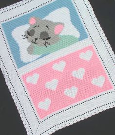 a crocheted baby blanket with hearts and a koala bear on the front