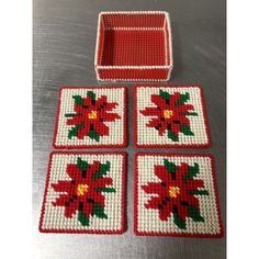 four red and white coasters with poinsettias on them