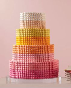 a multicolored cake is sitting on a table