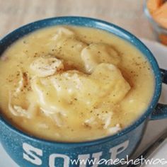 a blue cup filled with soup on top of a white plate