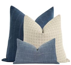 two blue and white pillows sitting next to each other