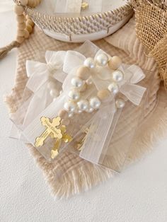 some white pearls and gold crosses are sitting on a table next to other items that include straw bags