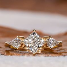 three stone diamond ring on top of a leaf