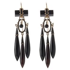 Composed of onyx, enamel and 14K gold, these antique pendant earrings were created around 1870. Each is designed as an onyx bar suspending a cascade of flexibly-set sphere, black enamel oval element and three tapering onyx drops with shaped enamel caps, accented by applied beads. Freely moving and magically lightweight, these fabulous antique earrings are delightfully intricate and beautiful. Product Details: Item #: ER-21022 Circa: 1870 Dimensions: 2.75" length x 0.75" width Materials: Onyx; Black Enamel; 14K Gold Macklowe Gallery Curator's Notes: Earrings and necklaces with elongated torpedo shape drops referenced Etruscan and Greek forms that had been imaginatively enlarged and reinterpreted by French and Italian Archaeological Revival jewelers such as Fontenay and Castellani. Luxury Black Enamel Formal Earrings, Red Priestess, Onyx Bar, Helaena Targaryen, Ritual Magic, Lady In Waiting, Antique Pendant, White Dragon, Antique Earrings