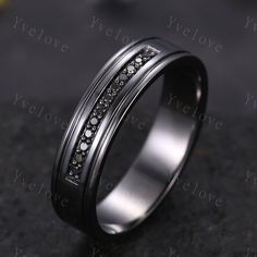 a wedding band with black and white diamonds inlayed to the inside of it