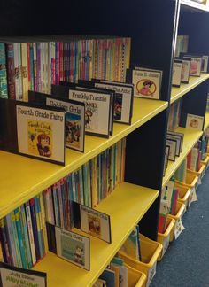 several books on yellow shelves in a library with blue carpeting and walls lined with children's books