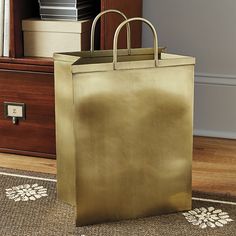 a gold shopping bag sitting on top of a rug