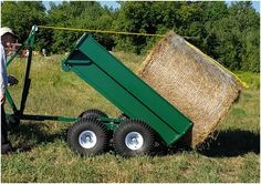 a man is pulling a hay bale on a dolly with it's wheels