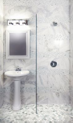 a white sink sitting under a mirror in a bathroom