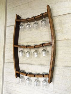 a wooden shelf with wine glasses hanging from it's sides and on the wall