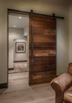 a brown leather chair sitting in front of a wooden door