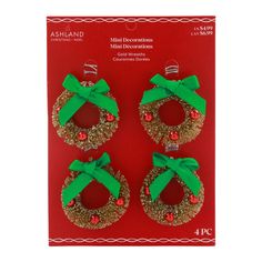 three christmas wreaths with green bows and red berries on them in front of a card