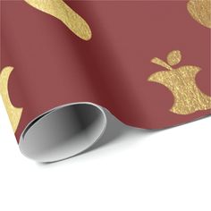 an apple wallpaper with gold apples on red and gold foil wrapping paper, which is rolled up to the side