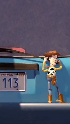 a toy story character standing in front of a blue car with the number thirteen on it's license plate