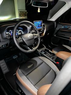 the interior of a vehicle with leather seats and steering wheel, dash lights, and dashboard controls