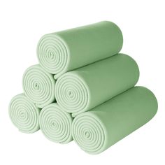 four rolled up yoga mats stacked on top of each other in mint green color,