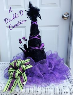 a purple and black witch hat sitting on top of a white chair next to a door