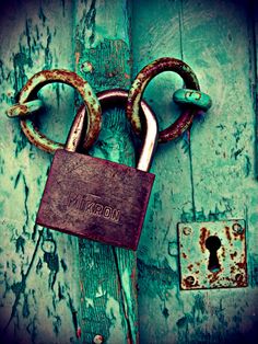 an old padlock and chain on a wooden door