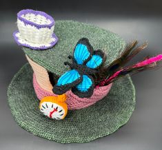 a crocheted hat with two hats on top of it and a cat toy