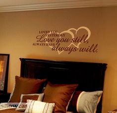 a bedroom with a large bed and two framed pictures on the wall above it that says love you still always until