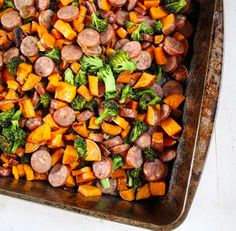 a pan filled with sausage, broccoli and sweet potatoes