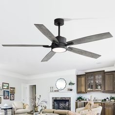 a living room with a ceiling fan in it's center and two couches