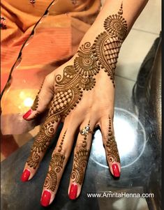 a woman's hand with henna tattoos on it