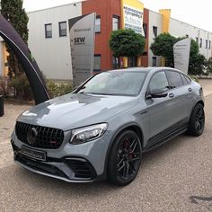 a grey mercedes glc parked in front of a building