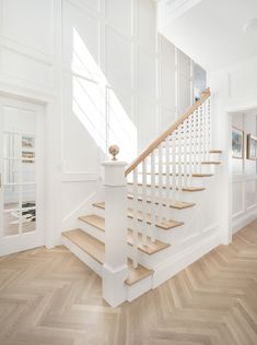 an image of a white staircase in a house with wood flooring and hardwood floors