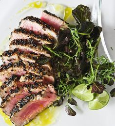 a white plate topped with meat and greens