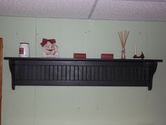 there is a shelf above the bed with candles and other items on top of it