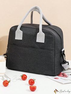 a gray bag sitting on top of a table next to some tomatoes and a knife