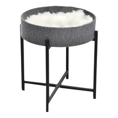 a grey and white round table with fur on the top, black metal frame legs