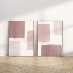 two pink and white paintings on the wall in an empty room with wood flooring