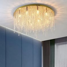 a chandelier hanging from the ceiling in a room with blue walls and curtains