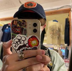 a person holding up a cell phone with stickers on it