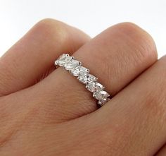 a woman's hand with a diamond ring on her left hand, showing the side stones