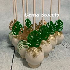 there are some cake pops decorated with leaves and gold glitters on the top, along with candles