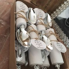 there are many silverware in the box with tags on each fork and spoons