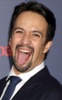 a man with his mouth open and tongue out in front of him is making a funny face