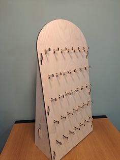 a wooden board with pegs attached to it on top of a table next to a wall