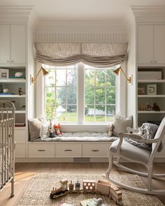 a baby's room with a rocking chair, window seat and bookshelf